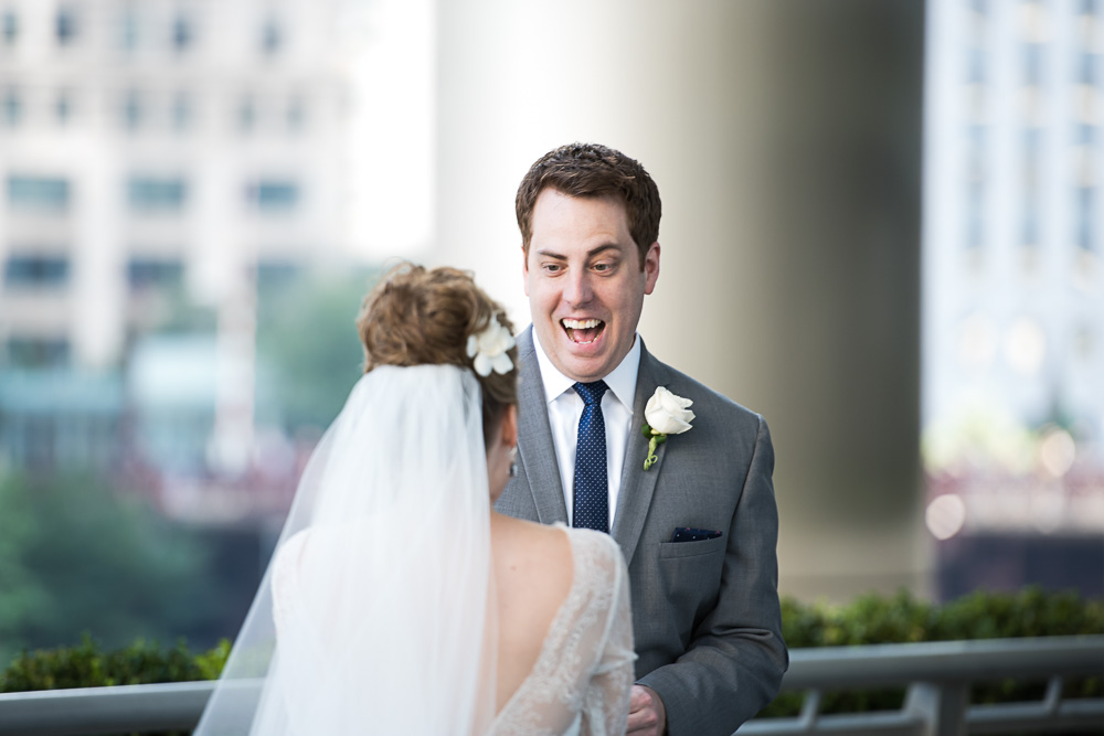 Groom reacts with big smile during the first look.